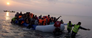 Volunteers help migrants and refugees on a dingy as they arrive at the shore of the northeastern Greek island of Lesbos, after crossing the Aegean sea from Turkey on Sunday, March 20, 2016. In another incident two Syrian refugees have been found dead on a boat on the first day of the implementation of an agreement between the EU and Turkey on handling the new arrivals. (AP Photo/Petros Giannakouris)